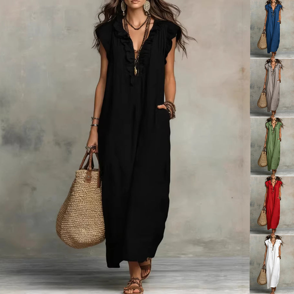 Woman wearing a black sleeveless dress holding a straw bag against a neutral background.