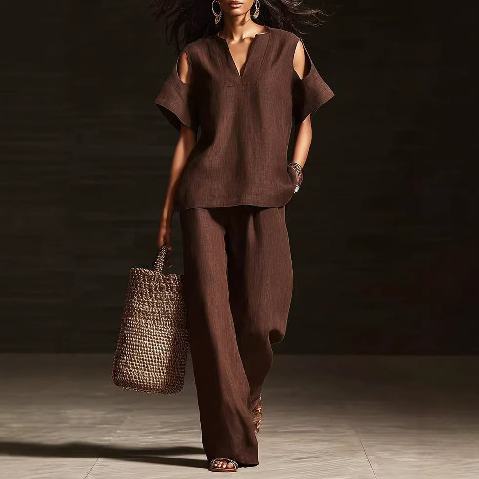 Woman in a brown outfit holding a woven bag on a dark background
