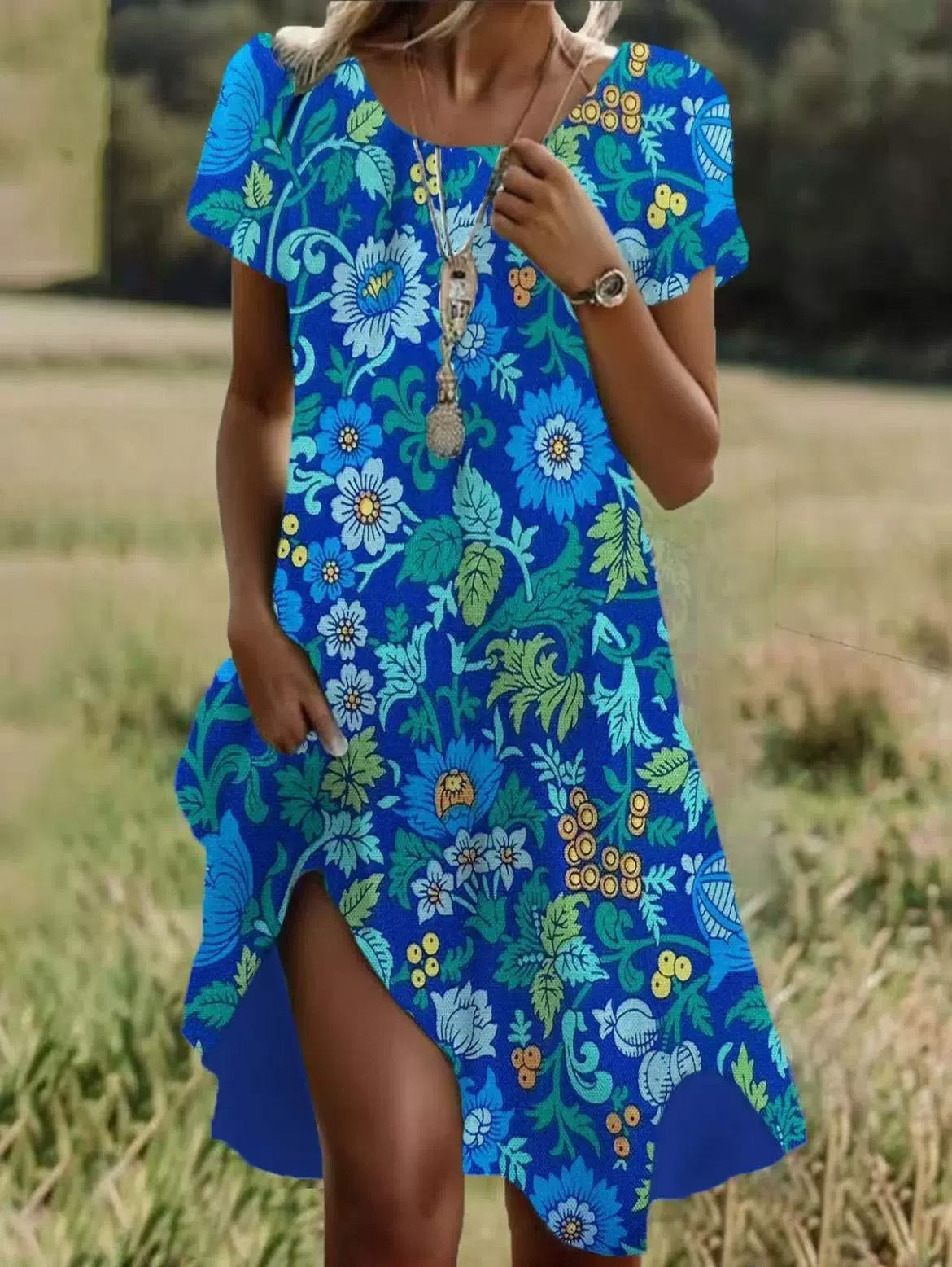 Woman wearing a blue floral dress standing in a field
