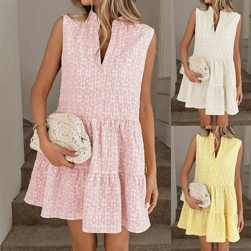 Woman wearing a pink dress with a white clutch, with another person in a yellow dress holding a white clutch.