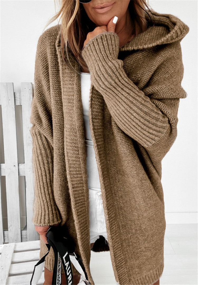 Person wearing a brown knitted cardigan with a blurred background