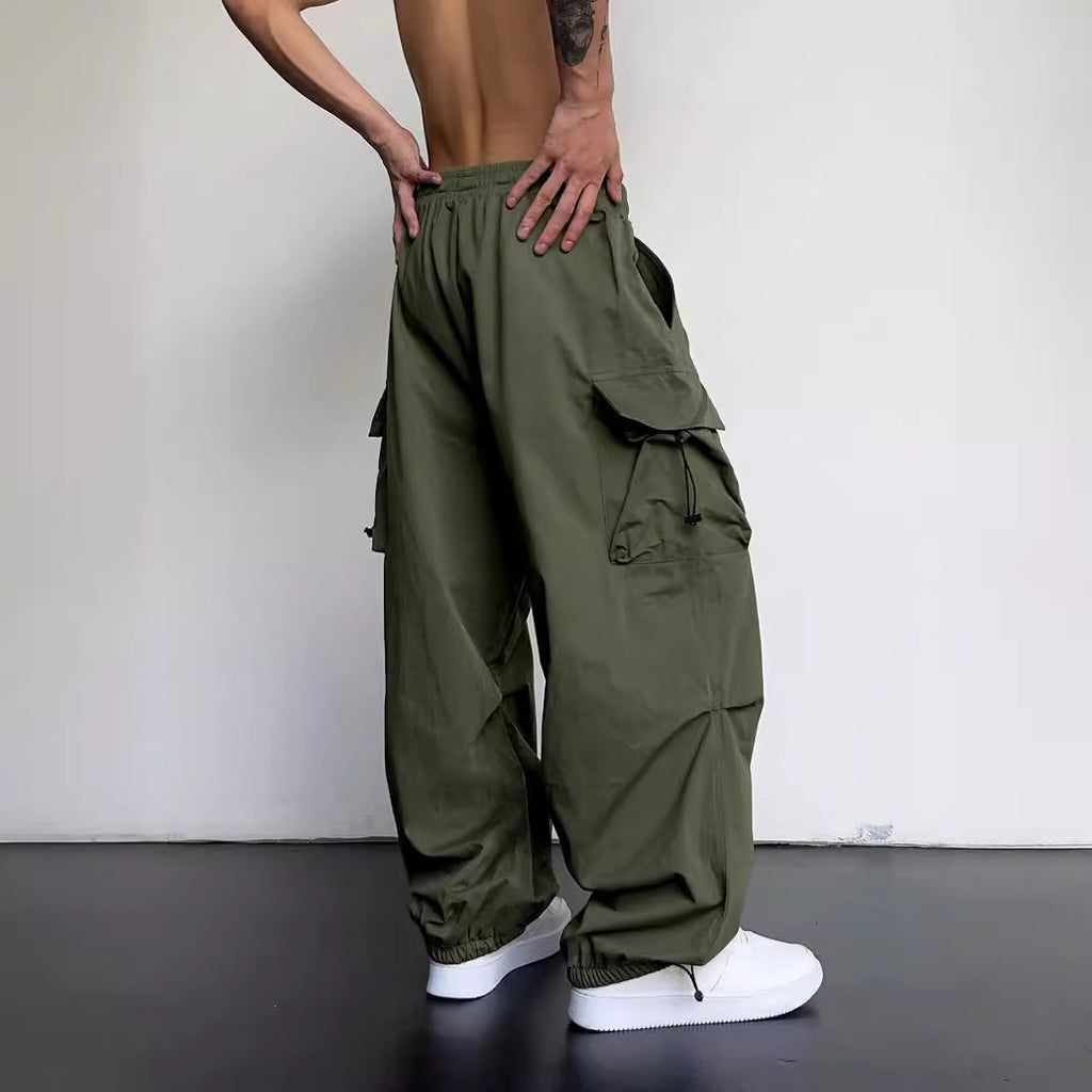 Person wearing olive green cargo pants with a plain background