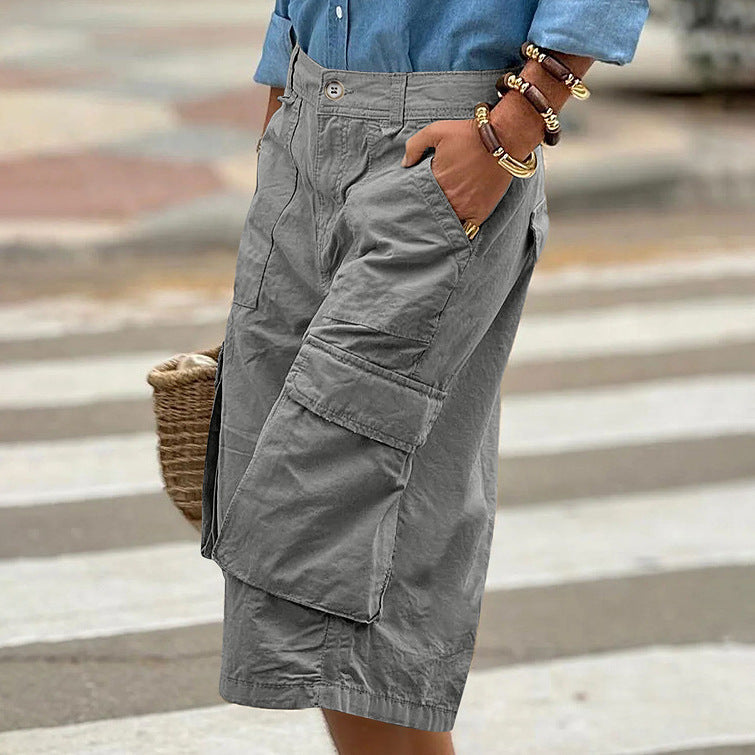 Person wearing gray cargo shorts with a blurred background