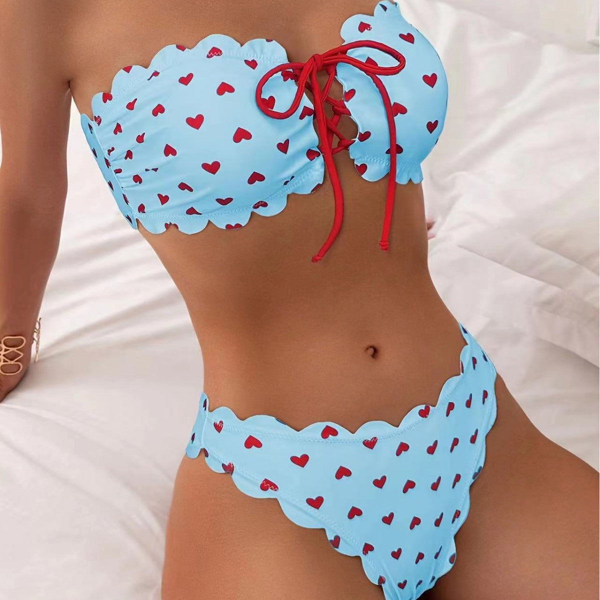 Blue bikini with red heart patterns on a white background