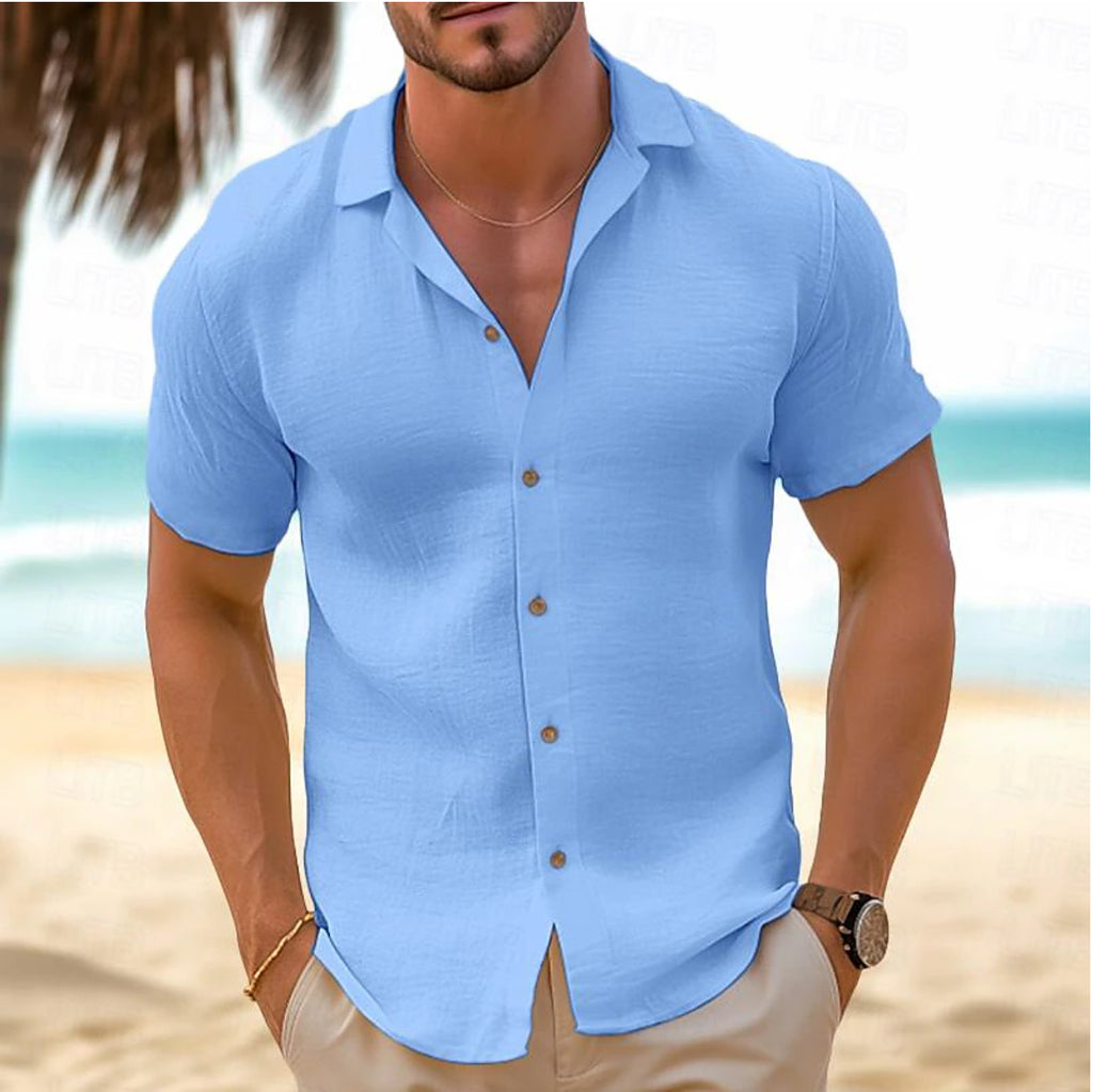Man wearing a light blue short-sleeve shirt on a beach