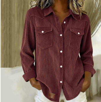 A woman wearing a long-sleeve corduroy button-up shirt in a deep burgundy or maroon color, paired with white pants. The photo is cropped from the shoulders down, showing the texture of the shirt and the white buttons.