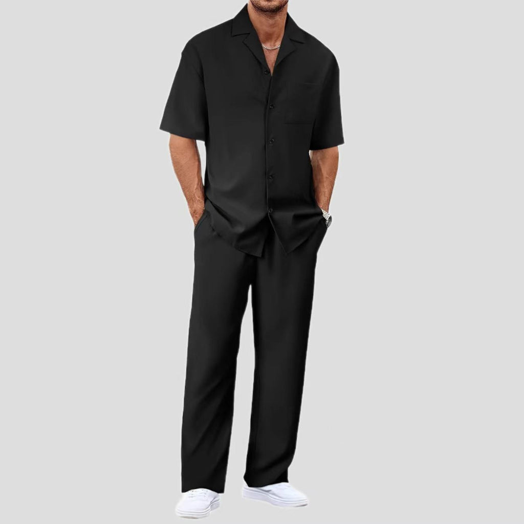 Person wearing a black outfit with a plain background