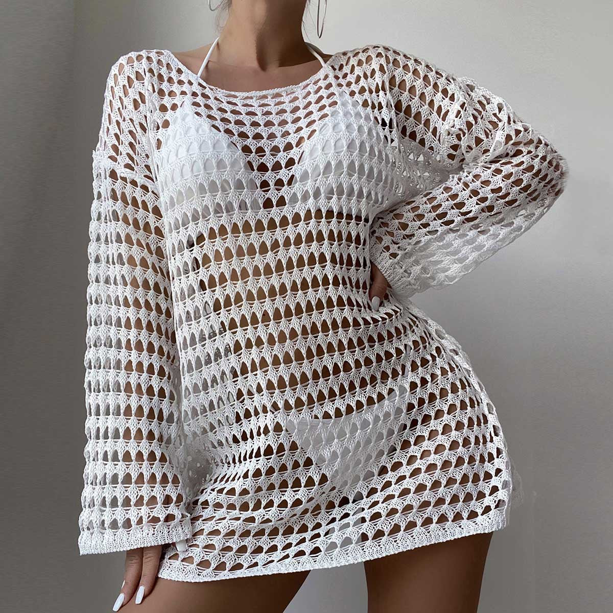 White crochet dress with long sleeves on a plain background