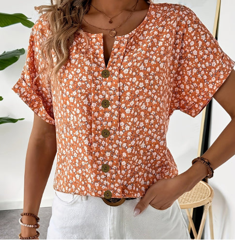 Woman wearing a floral blouse with buttons, standing indoors.