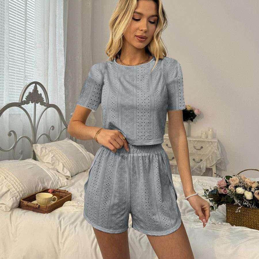 Woman wearing light blue eyelet lounge set in chic bedroom, ZA-Zola fashion collection