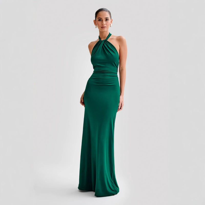 Woman wearing a green halter neck gown on a light gray background