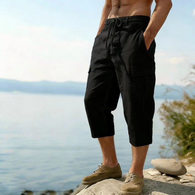 Person wearing black capri pants standing by a body of water.