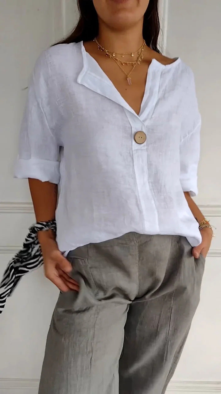 Person wearing a white shirt and gray pants against a neutral background