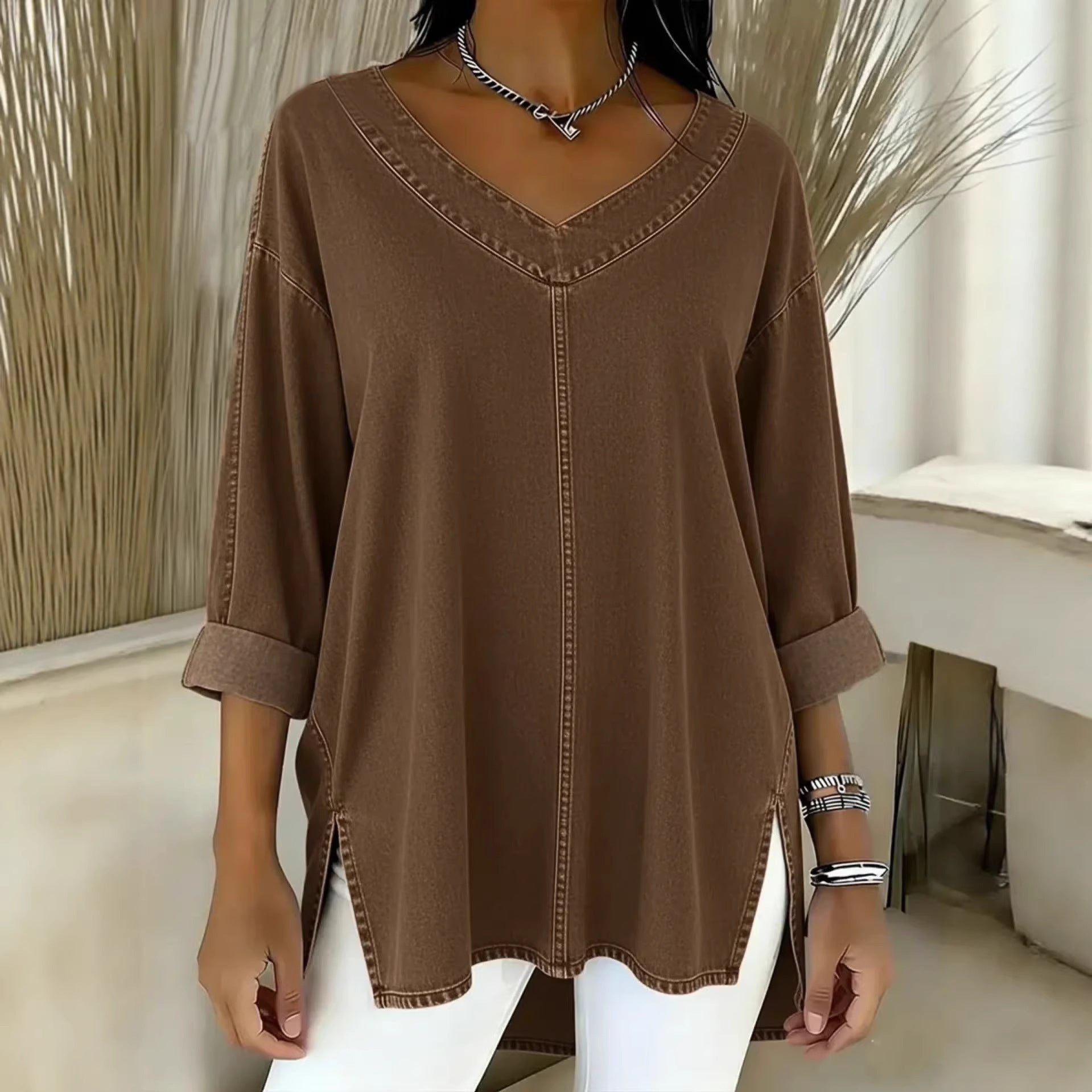 Brown long-sleeve top worn by a person in a minimal indoor setting