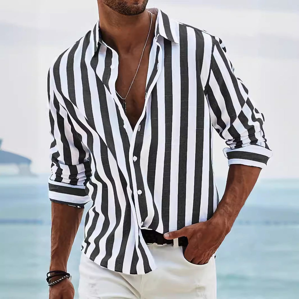 Man wearing a black and white striped shirt with a blurred beach background