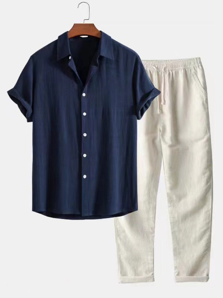 Navy shirt and beige pants on a hanger against a white background