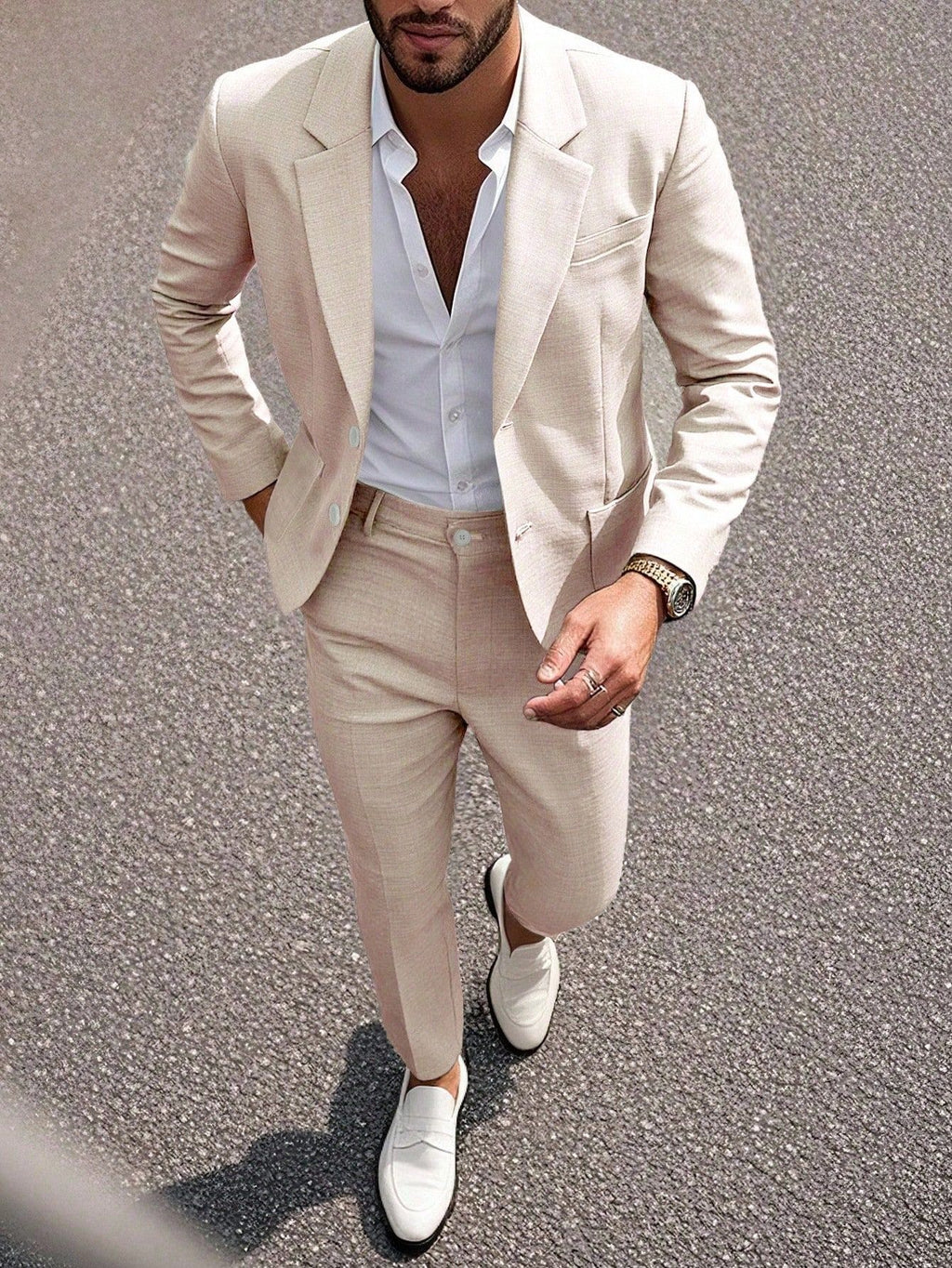 Man wearing a beige suit with white shirt and shoes on a textured surface