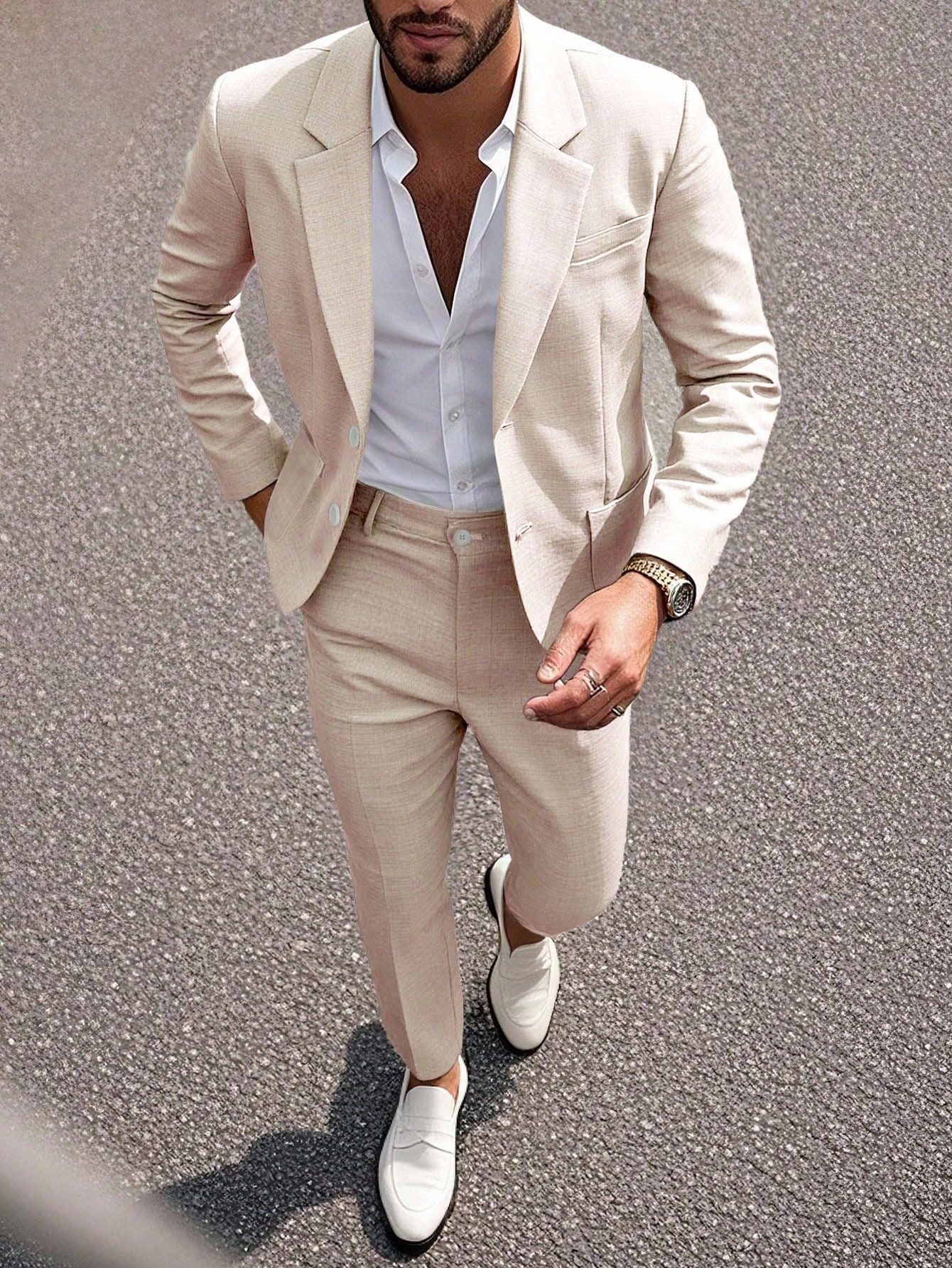 Man wearing a beige suit with white shirt and shoes on a textured surface