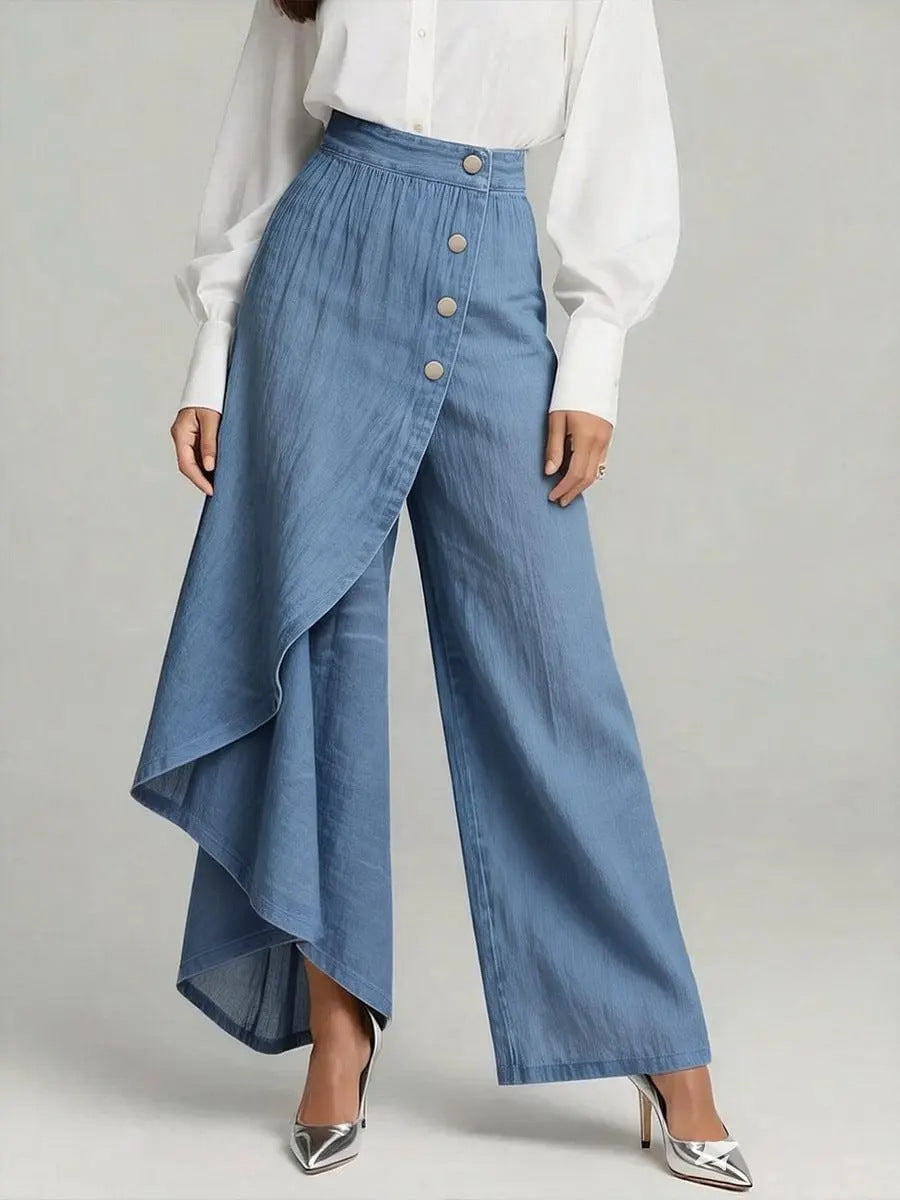 Person wearing a white blouse and blue denim pants with a button detail on a gray background
