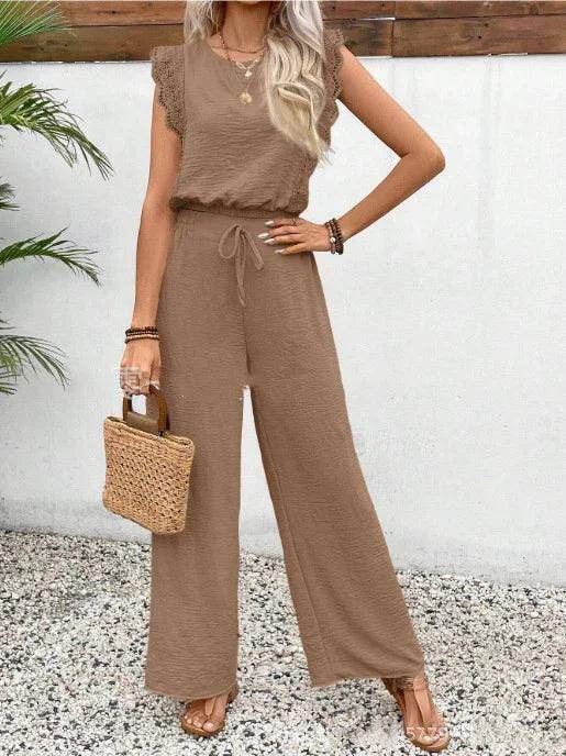 Woman in a chic brown jumpsuit with lace sleeves, straw bag, and sandals, ZA-Zola fashion