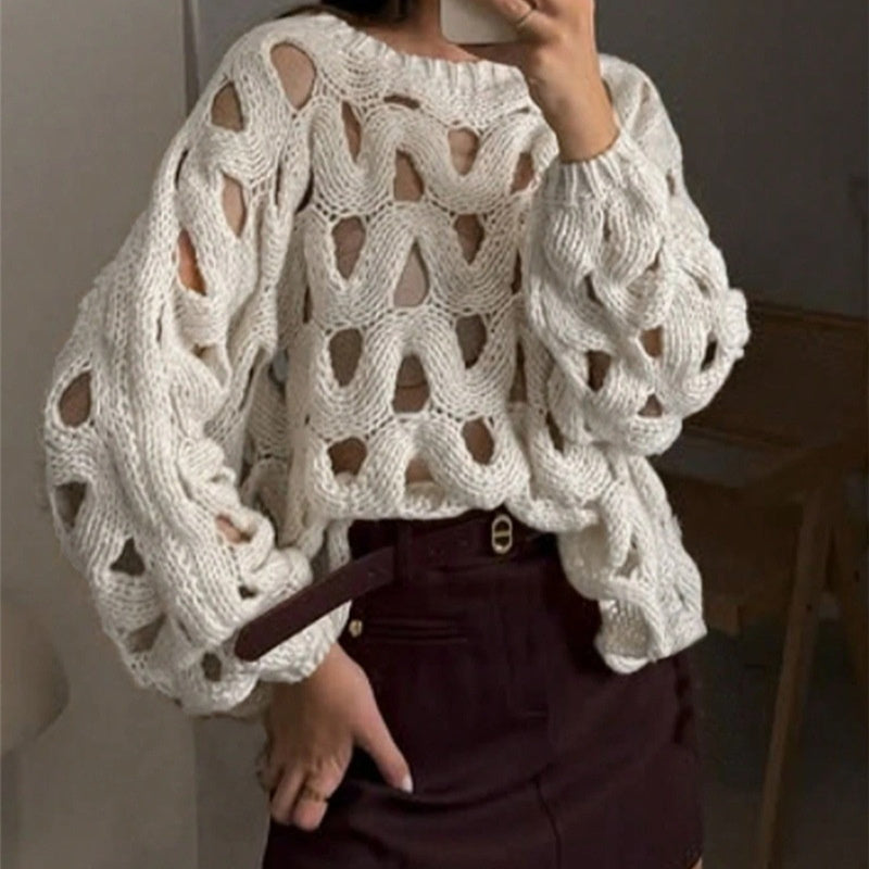 Person wearing a white knit sweater with a textured pattern.