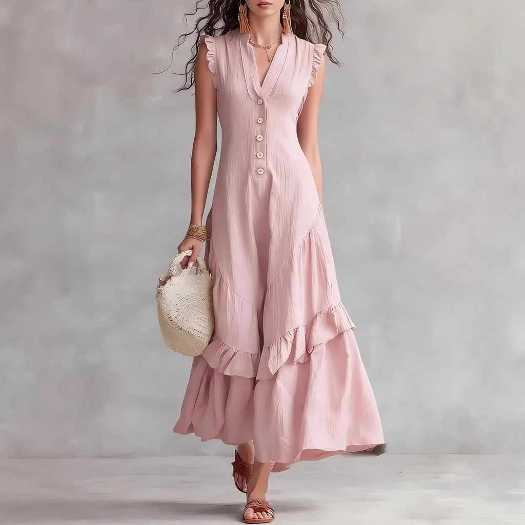 Woman wearing a pink dress holding a small bag against a plain background