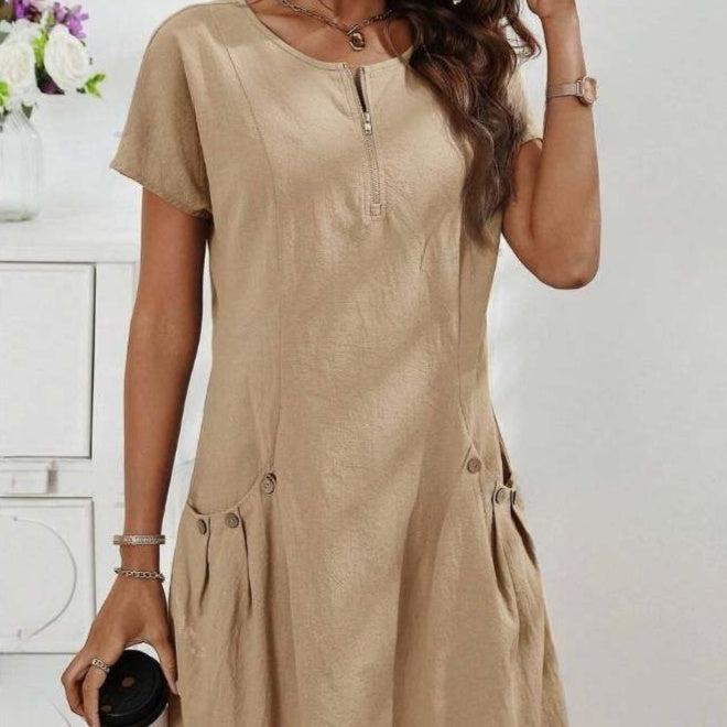 Woman wearing a beige dress with a neutral background