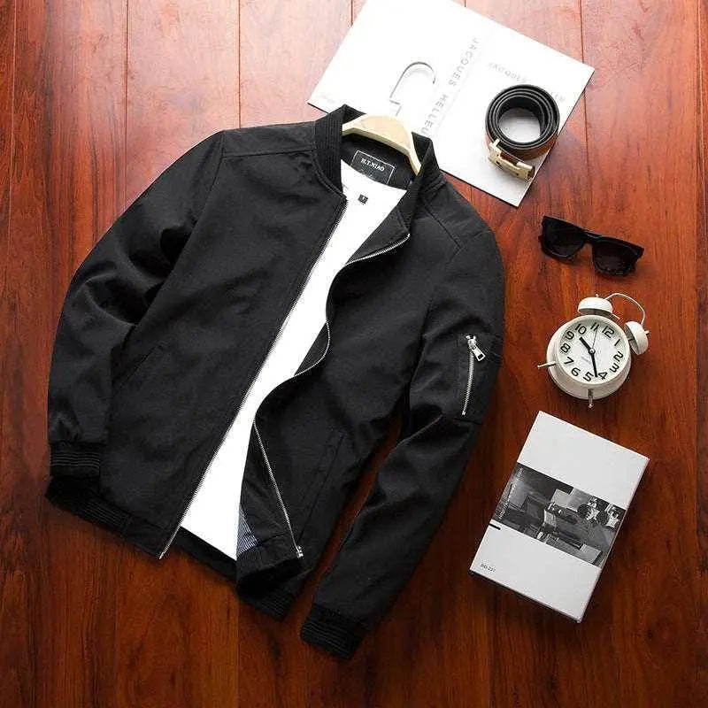 Men's black casual bomber jacket from ZA-Zola, styled with belt, sunglasses, and watch on wood floor