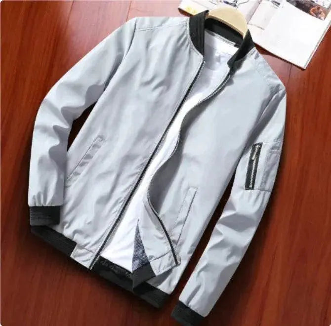 Light grey men's casual bomber jacket with black ribbed cuffs, displayed on wooden surface, ZA-Zola fashion