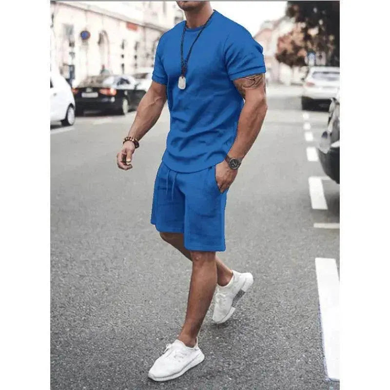 Man wearing blue summer sportswear set with T-shirt and shorts by ZA-Zola on city street