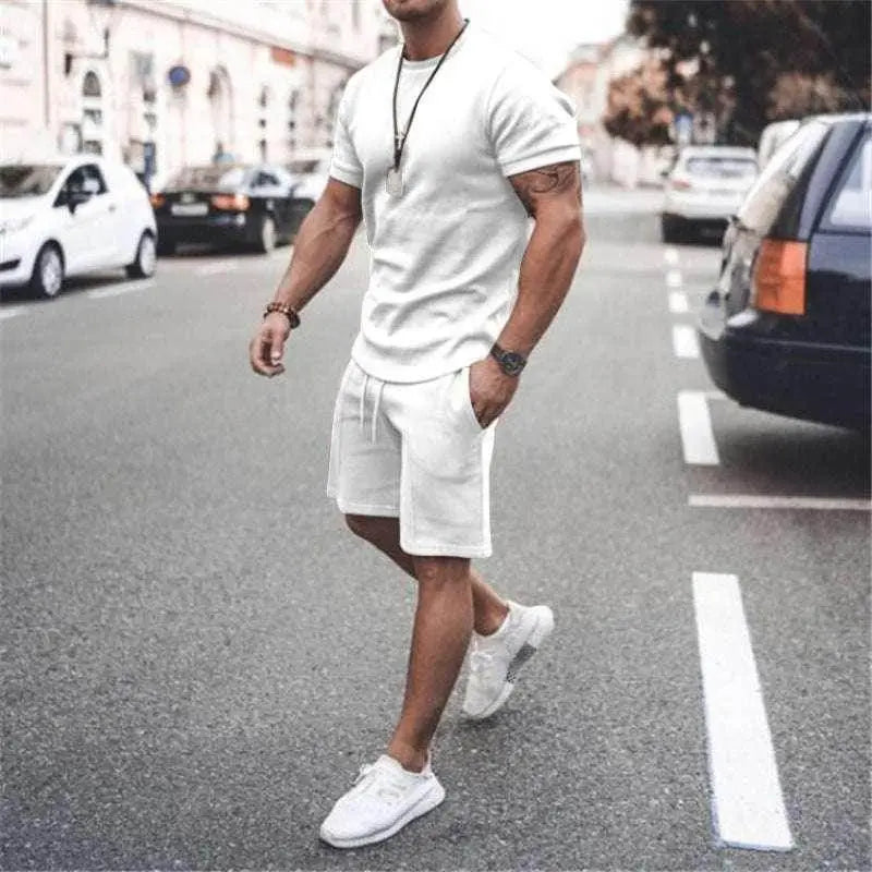 Man wearing white summer sportswear set with tee and shorts from ZA-Zola walking outdoors
