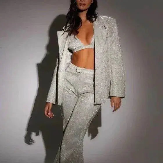 Woman modeling ZA-Zola sequin bra, blazer, and trousers party suit set against plain backdrop