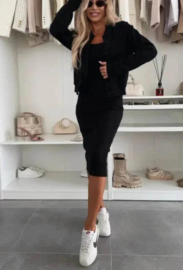 Woman in black sling dress and cardigan set from ZA-Zola, posing in a modern boutique