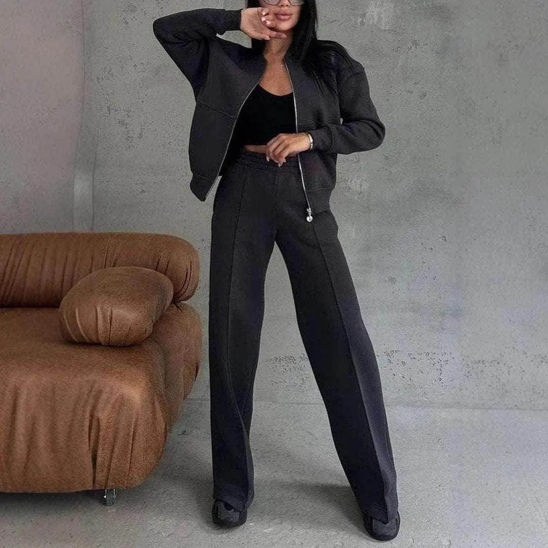 Woman modeling black zipper jacket and wide-leg pants 2-piece set from ZA-Zola, modern interior