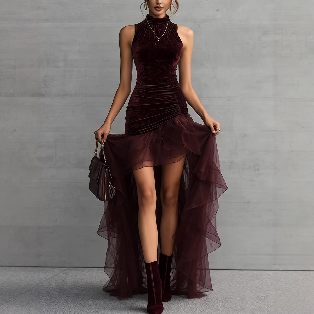 Woman wearing a burgundy velvet dress with sheer overlay against a gray background
