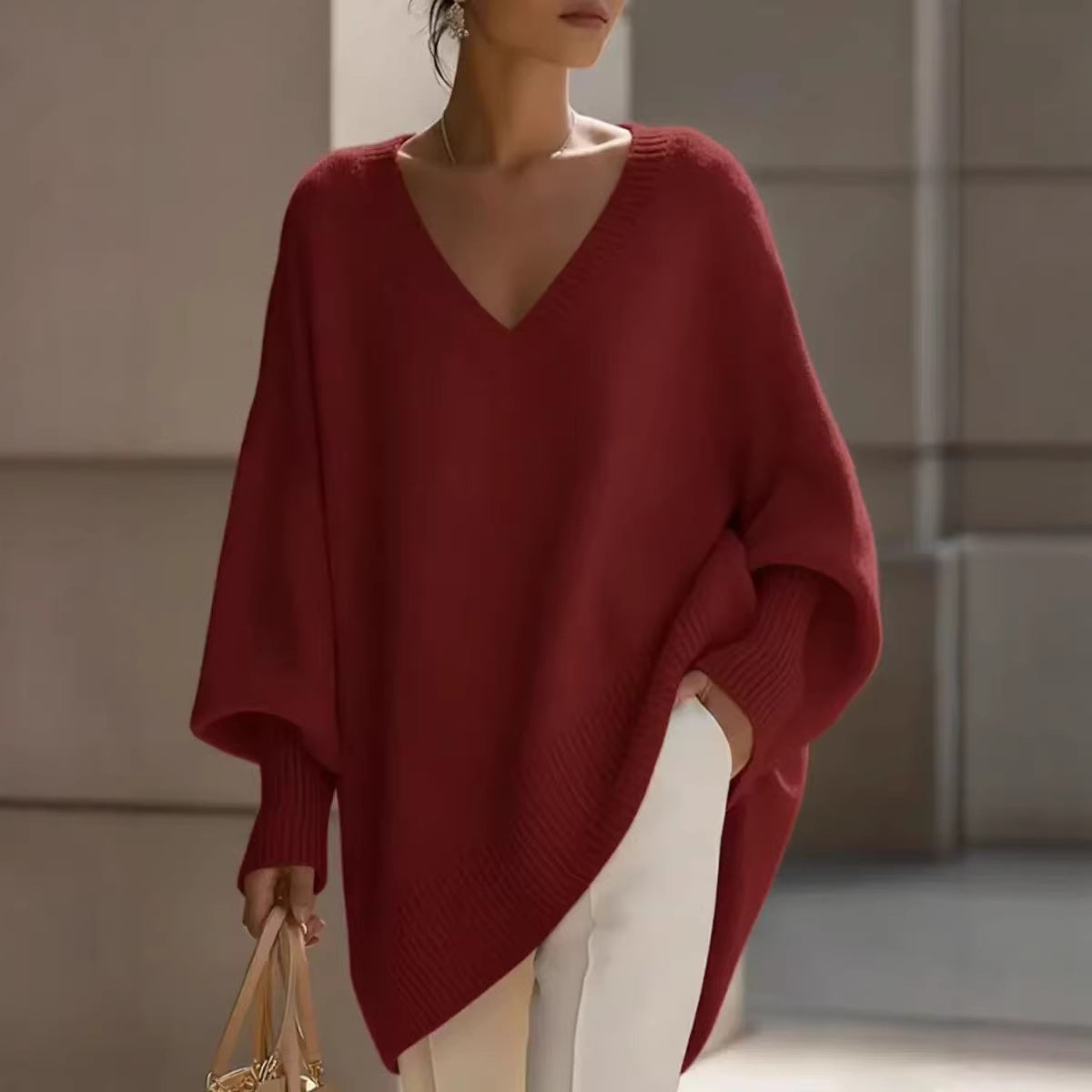 Woman wearing a red sweater and white pants in an indoor setting