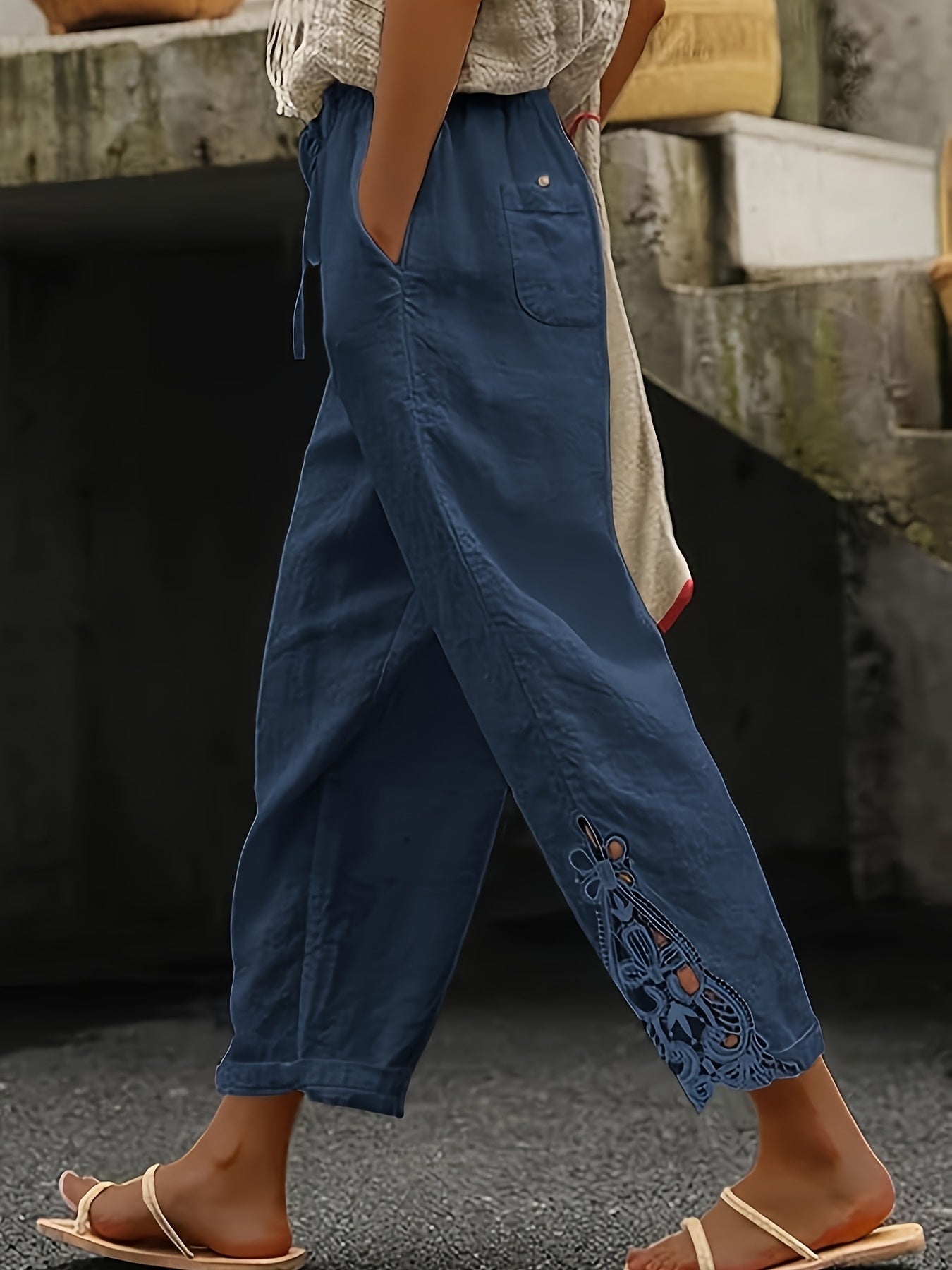 Person wearing blue pants with lace details in an outdoor setting