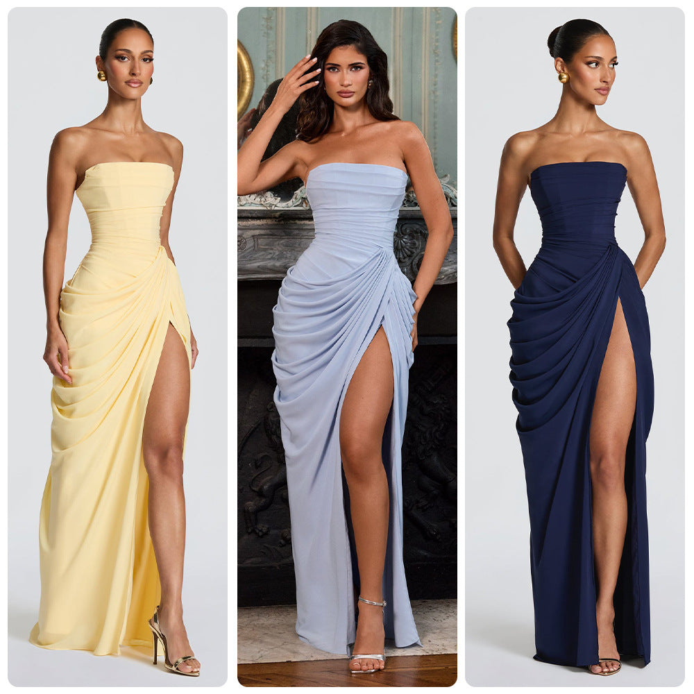 Three strapless evening gowns in yellow, blue, and navy with high slits on a white background.