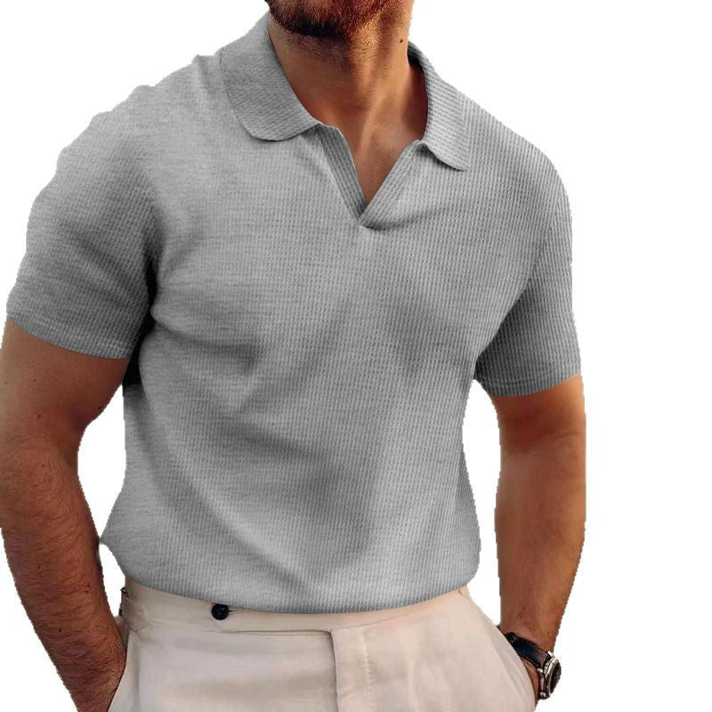 Man wearing a gray checkered polo shirt on a white background