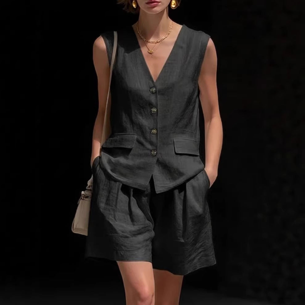 Person wearing a dark gray sleeveless top and shorts with a black background