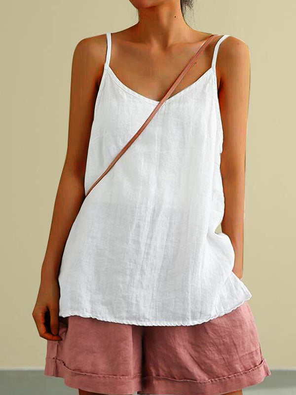 Person wearing a white sleeveless top and pink shorts with a beige background