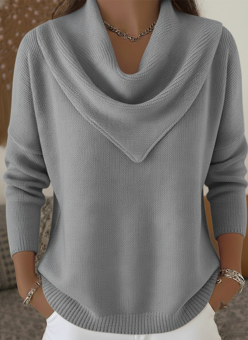 Gray sweater worn by a person with a blurred background
