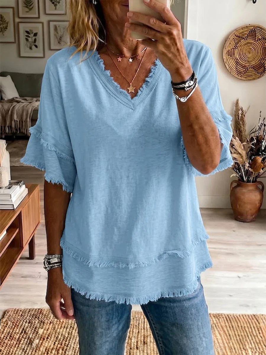 Person wearing a light blue blouse with ruffled sleeves in a living room setting.