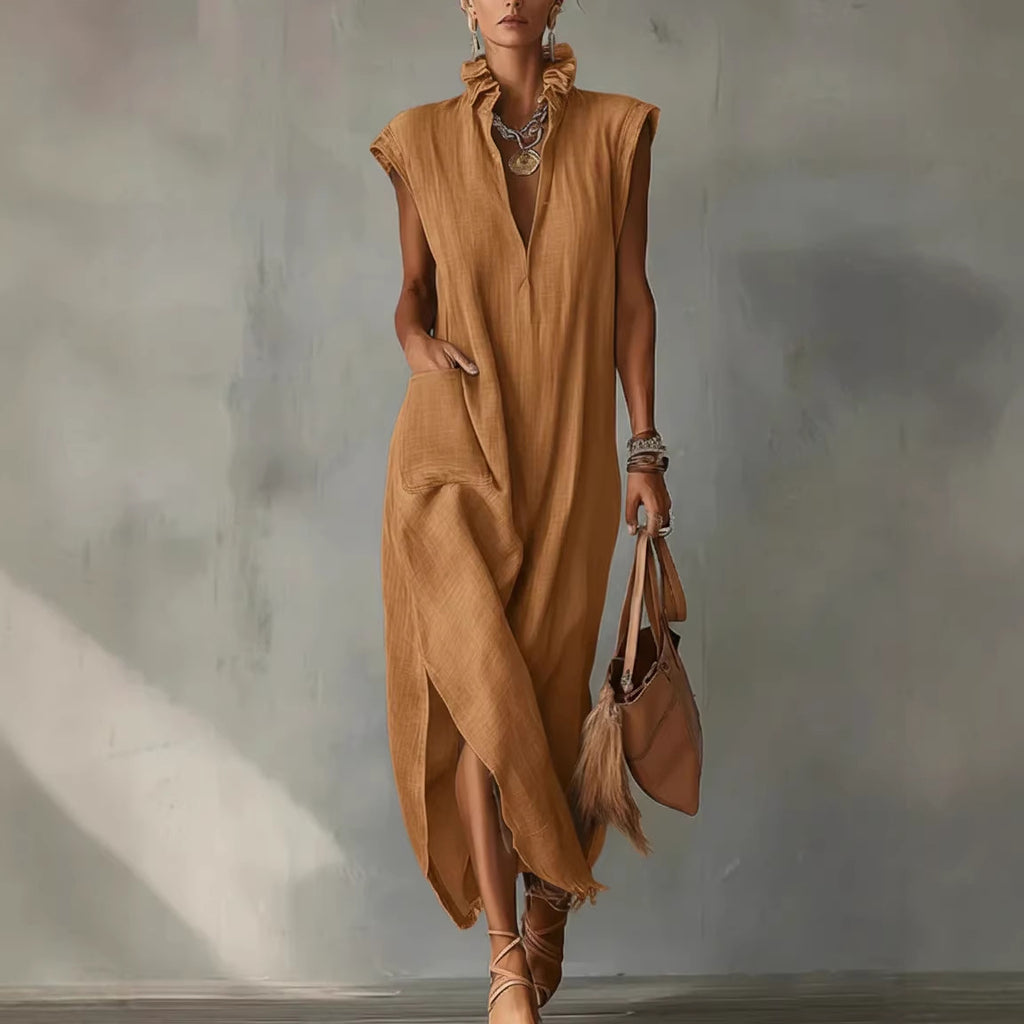Woman wearing a brown dress holding a matching handbag against a neutral background