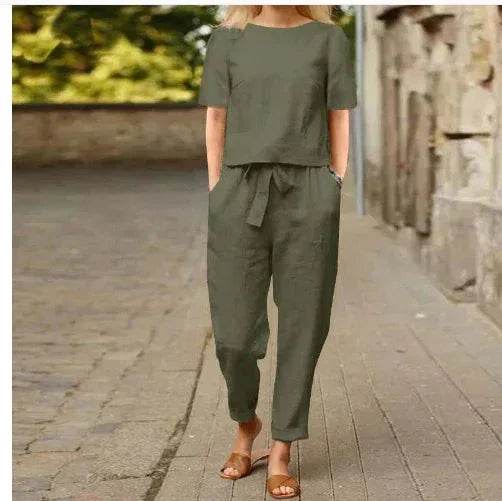 Woman wearing an olive green jumpsuit with short sleeves from ZA-Zola, walking outdoors