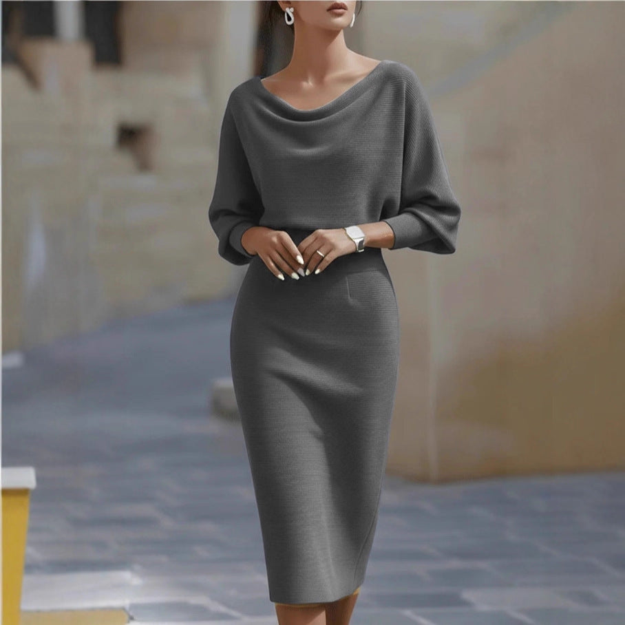 Woman wearing a gray dress standing on a stone pavement.