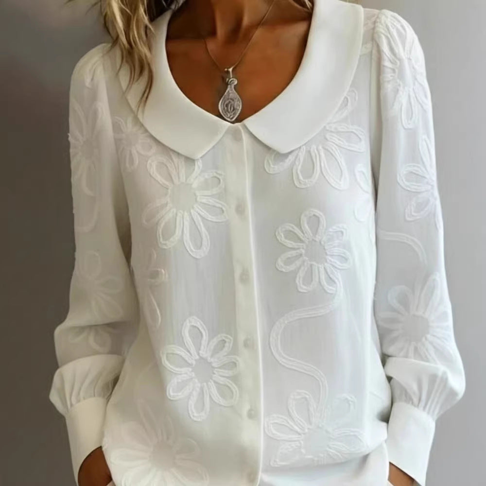 White blouse with floral embroidery on a plain background