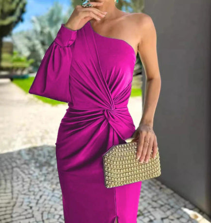 Woman in a vibrant purple one-shoulder dress holding a gold clutch.
