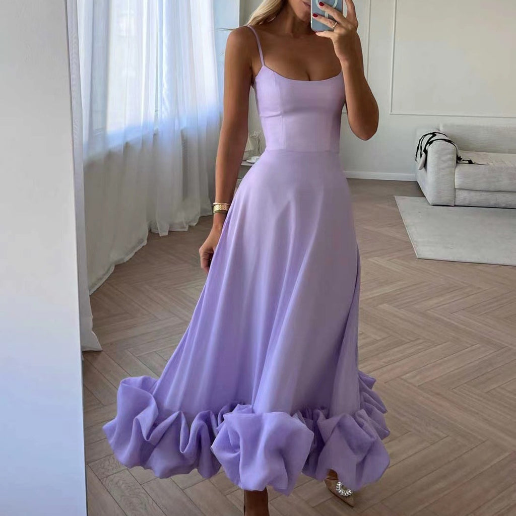 Woman wearing a lavender dress with ruffled skirt in a room.