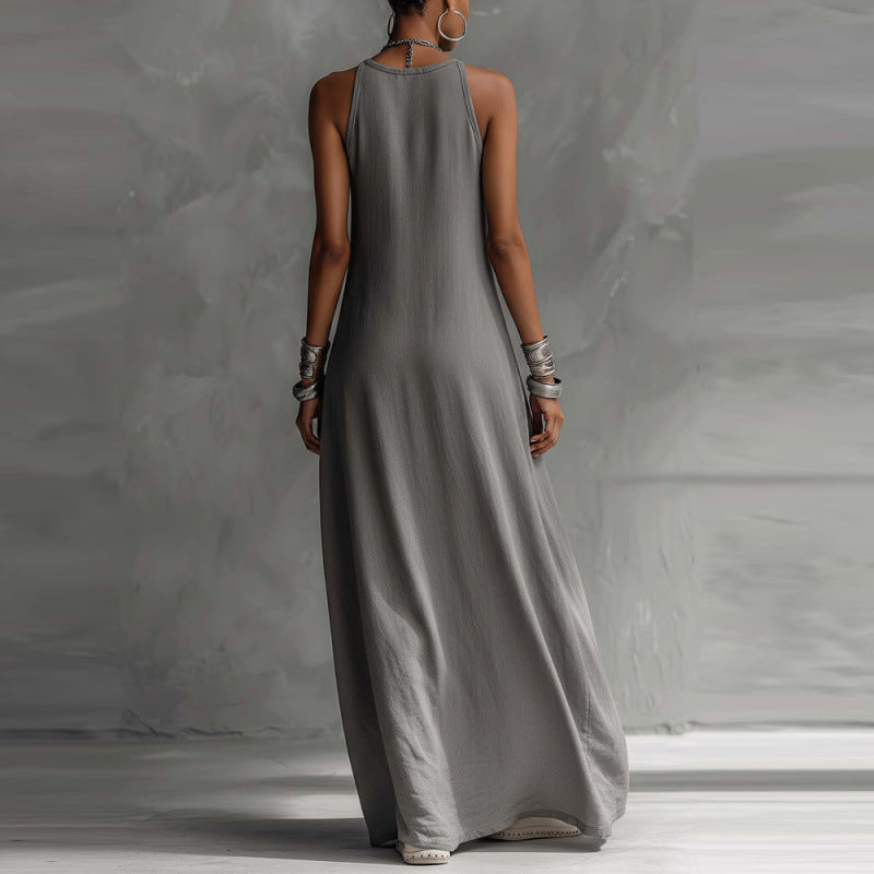 Woman wearing a long gray dress against a plain background
